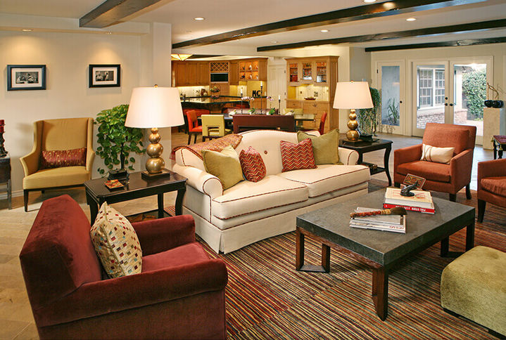 Traditional living room with a red armchair, beige sofa, and coffee table, Toluca Lake.