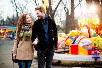 Couple walking hand-in-hand at fair