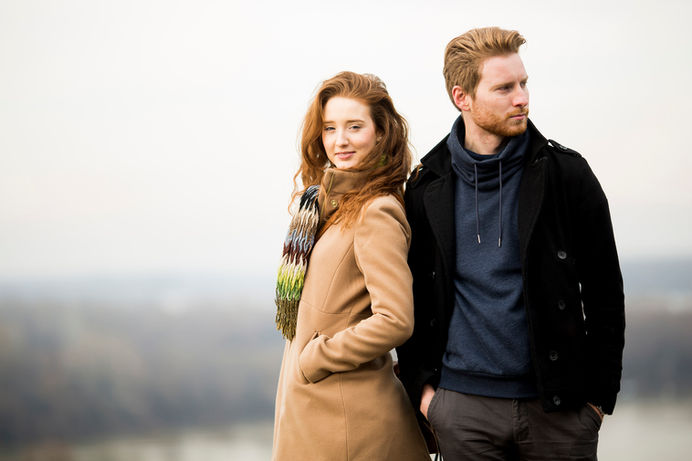 Woman in tan coat and man in dark jacket outdoors