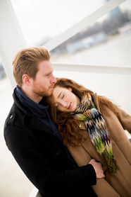 Couple embracing, woman resting head on man's shoulder