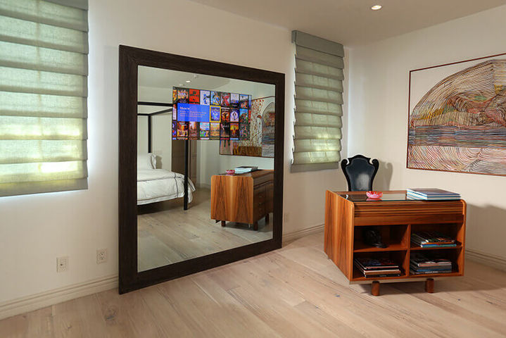 Bedroom featuring a large floor mirror reflecting the bed and a wooden cabinet, Pacific Palisades.