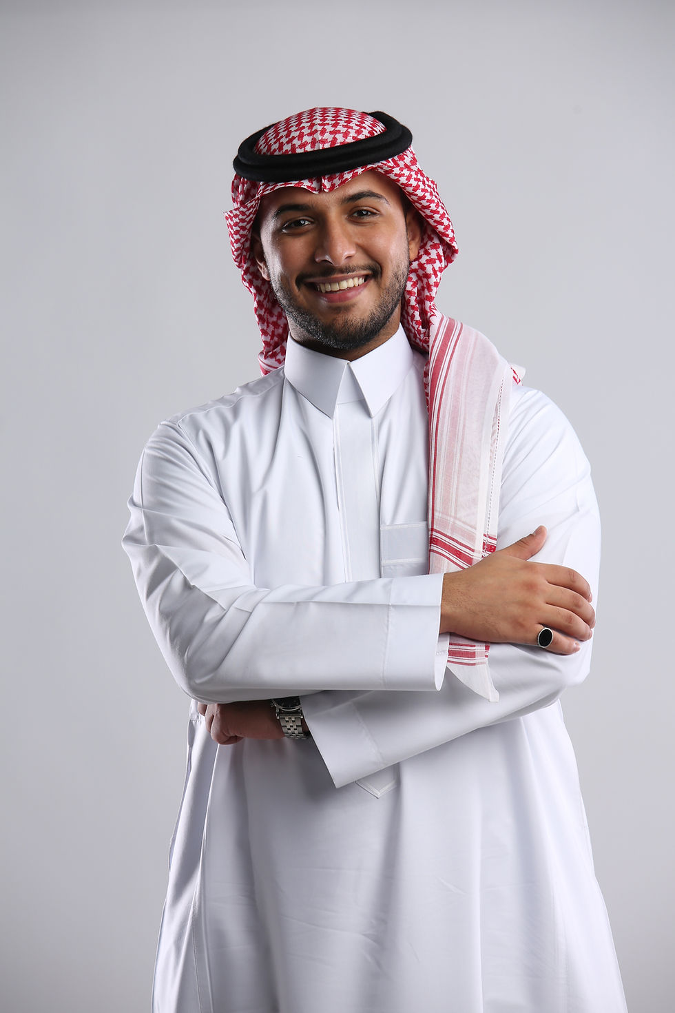SOLO saudi-arabian-man-standing-holding-both-arms-together-smiling-front-angle.jpg