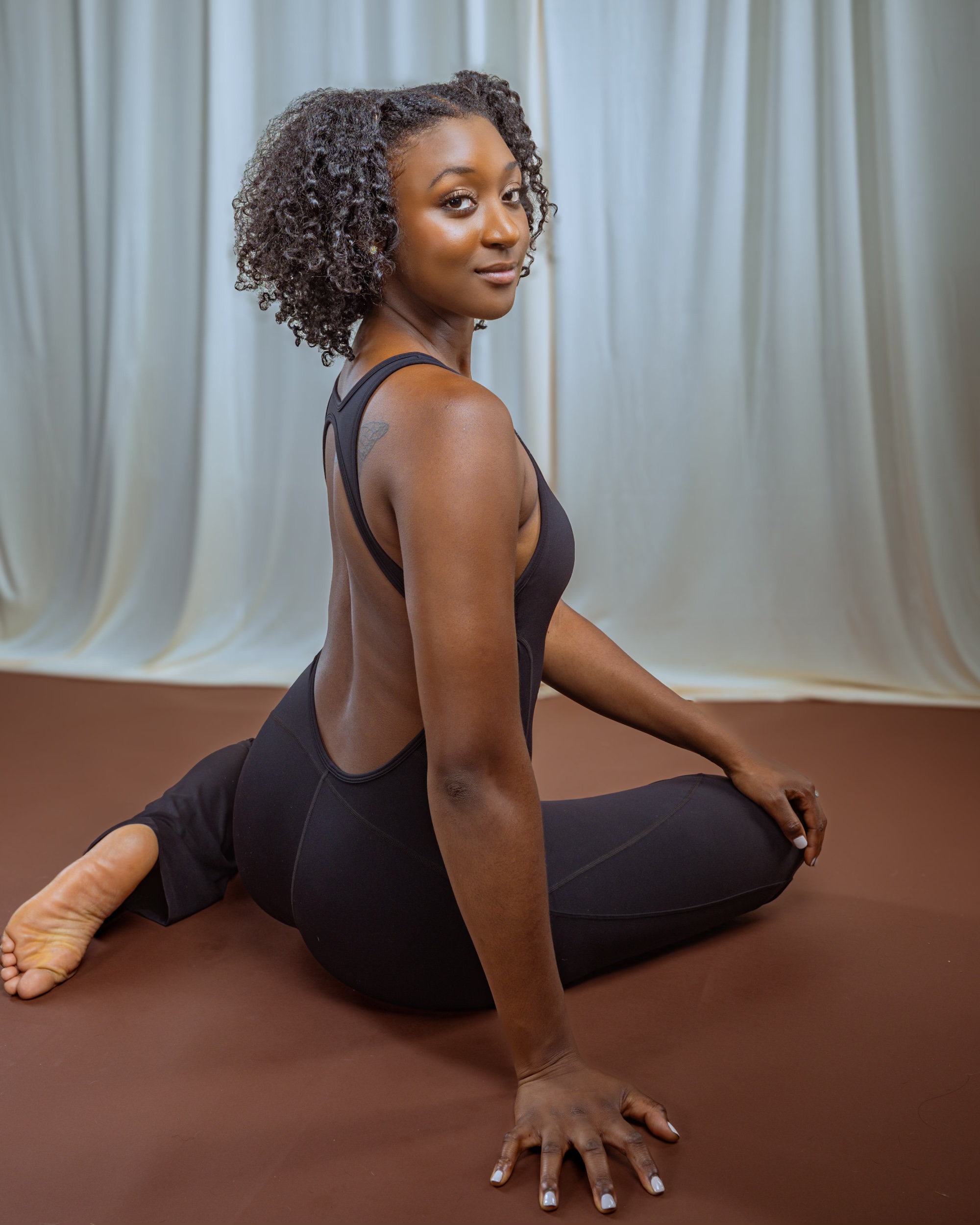 A soft minimalist yoga mat folded elegantly with a small sprig of lavender on top.