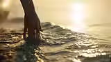 women with hand in ocean.avif
