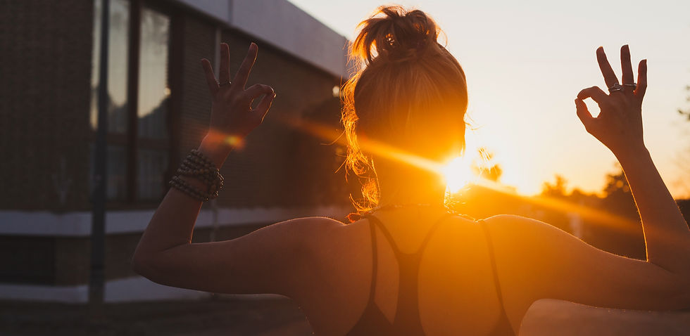 mulher com vista traseira meditando no pôr do sol