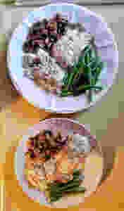 Two plates featuring salmon, mushrooms, green beans, and rice.