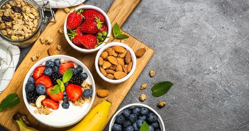 Bowls of berries, almonds, and granola on a wooden board—perfect examples of healthy snacks for weight loss.
