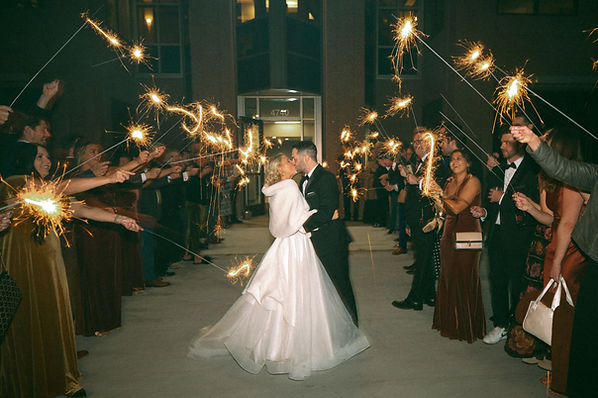 bride and groom kissing as they walk through their sparkler exit photographed by a Kansas City Wedding photographer