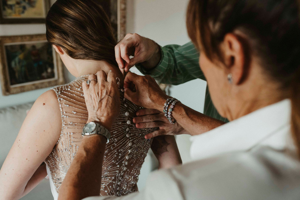 Novia vistiendose antes de la boda ayudada por su madre