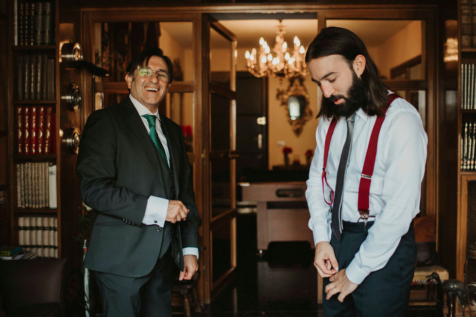 Padre ayudando a vestir a su hijo antes de la boda