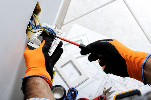 Electrician working safely on switches and sockets of a residential electrical system.jpg