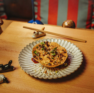 Asiatisk fusionrätt serverad på dekorativ tallrik med ätpinnar på träbord under vinlunch på Fagerudd.