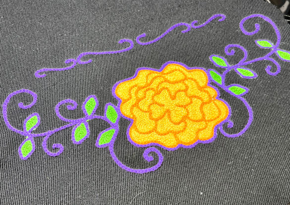 Chainstitch embroidered marigold on a black suit sample