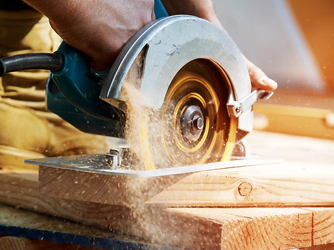Circular Saw blades cuts rafters on construction site