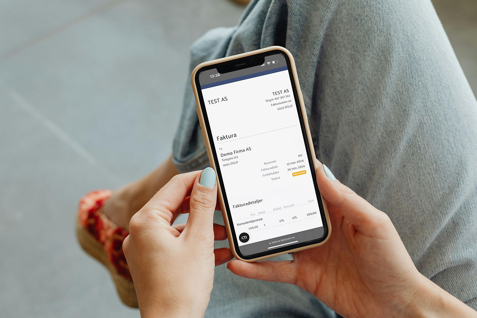 Person som holder en mobiltelefon og ser på en faktura fra TEST AS sendt via Fakturert.no. Fakturaen viser mottakerens informasjon, fakturadato, forfallsdato og totalbeløp.