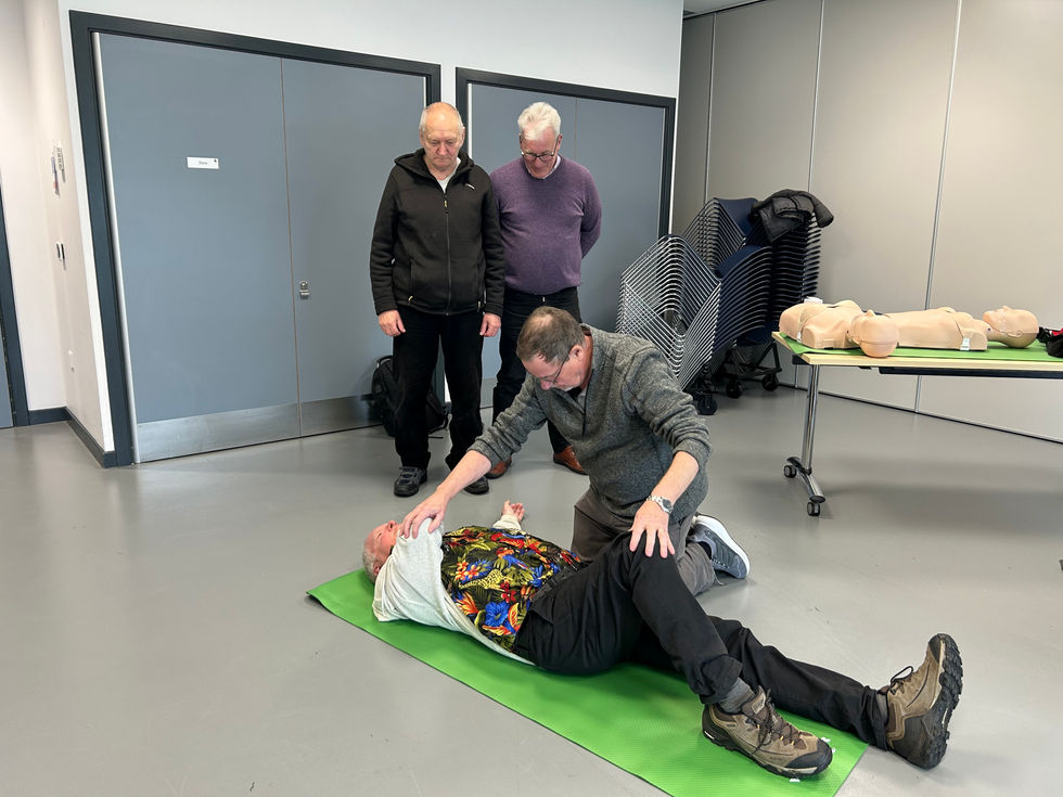 Members of Torry Men's shed practising stage 3 of recovery position