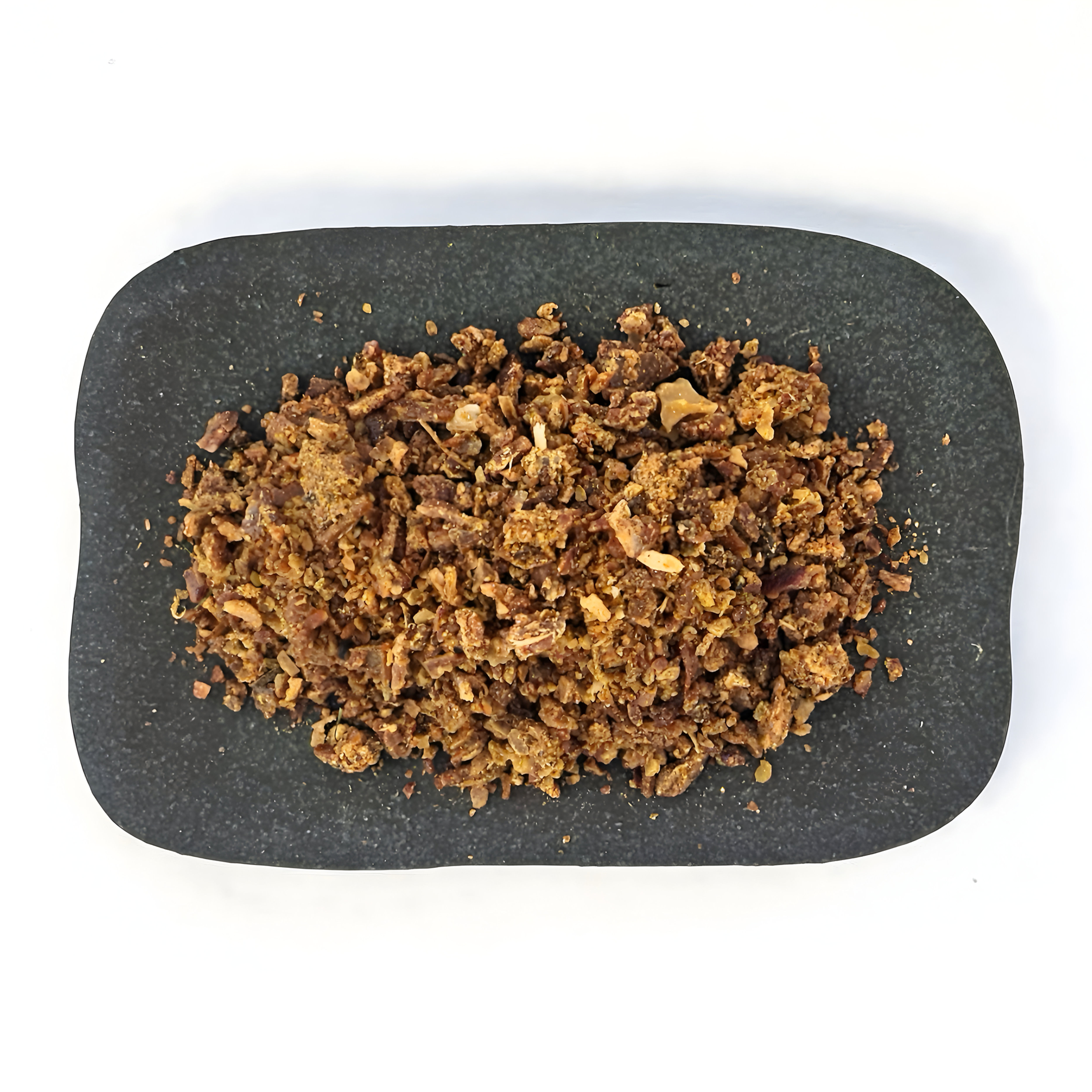 Raw propolis on a plate, showcasing its natural resin form and texture.