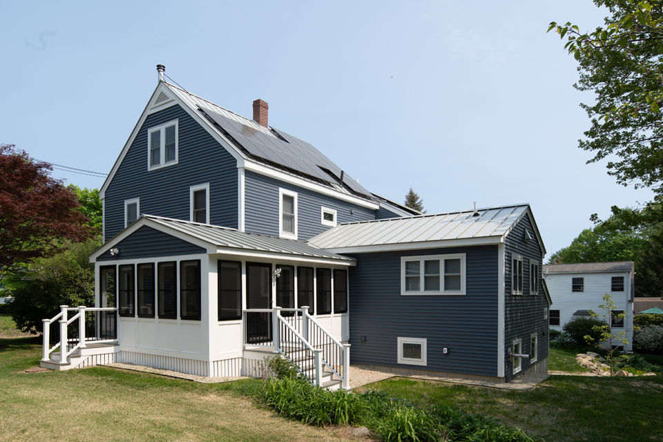 Two-story blue house with porch and solar panels