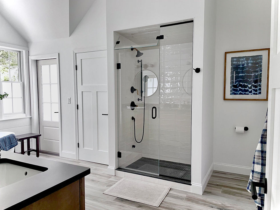 Contemporary bathroom upgrade with a glass shower enclosure, white subway tile, black shower fixtures, and shiplap wall trim by Property Essentials LLC in Kennebunk Maine.