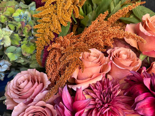 Autumn floral composition in the workshop with fuchsia dahlias, dusty pink roses, peach roses, golden amaranthus and hydrangeas — floral installation preparation for a wedding in Tuscany