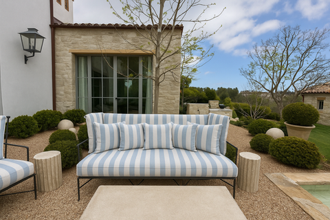 Custom outdoor bench cushions in Perennials Go To Stripe Ice Blue fabric on black metal frame, styled in a Mediterranean-style backyard in Malibu, California with gravel landscaping and modern garden elements