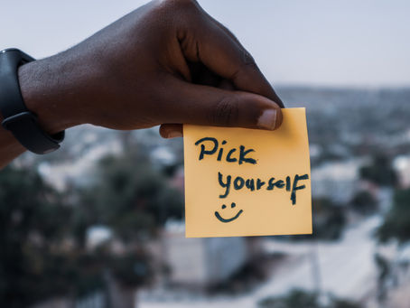 Hand holding post it note saying pick yourself