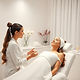 one esthetician in a consultation with one client with acne in a white spa suite.jpg