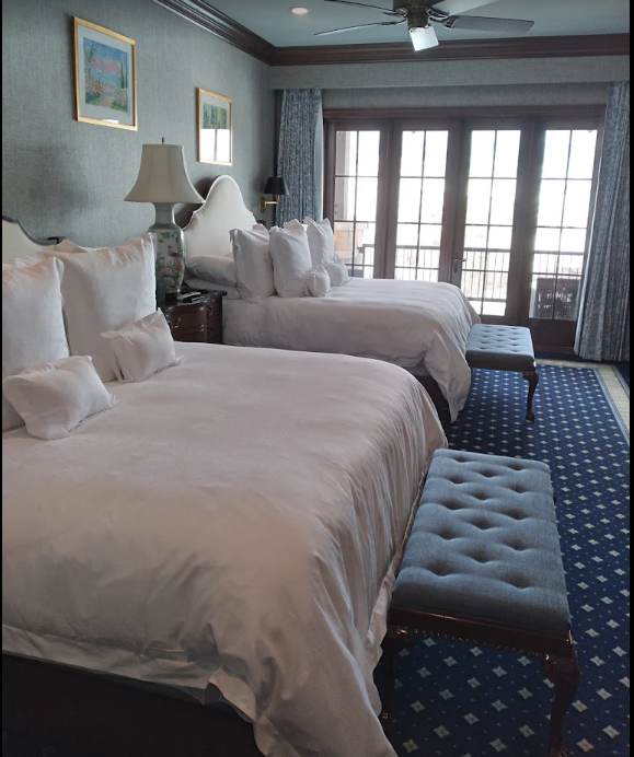 a hotel room with two beds and a bench