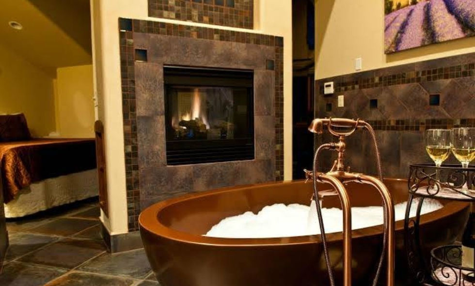 there is a tiled fireplace in the bathroom with a bathtub in front of it .