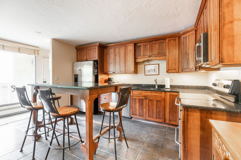 a kitchen with wooden cabinets and a stainless steel refrigerator