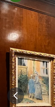 a painting in a gold frame is hanging on a wooden wall .