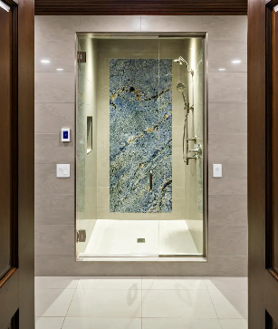 a walk in shower with a blue stone wall