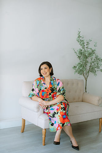 Edith Gutierrez seated on a sofa, looking content and at ease in a warm, inviting living room.