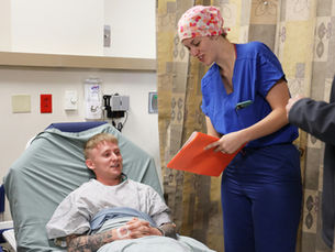 Perioperative nurse educator talking with a patient before surgery