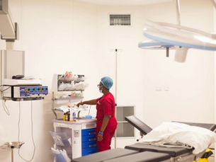 A perioperative nurse preparing instruments at a trolley in a hospital operating theatre