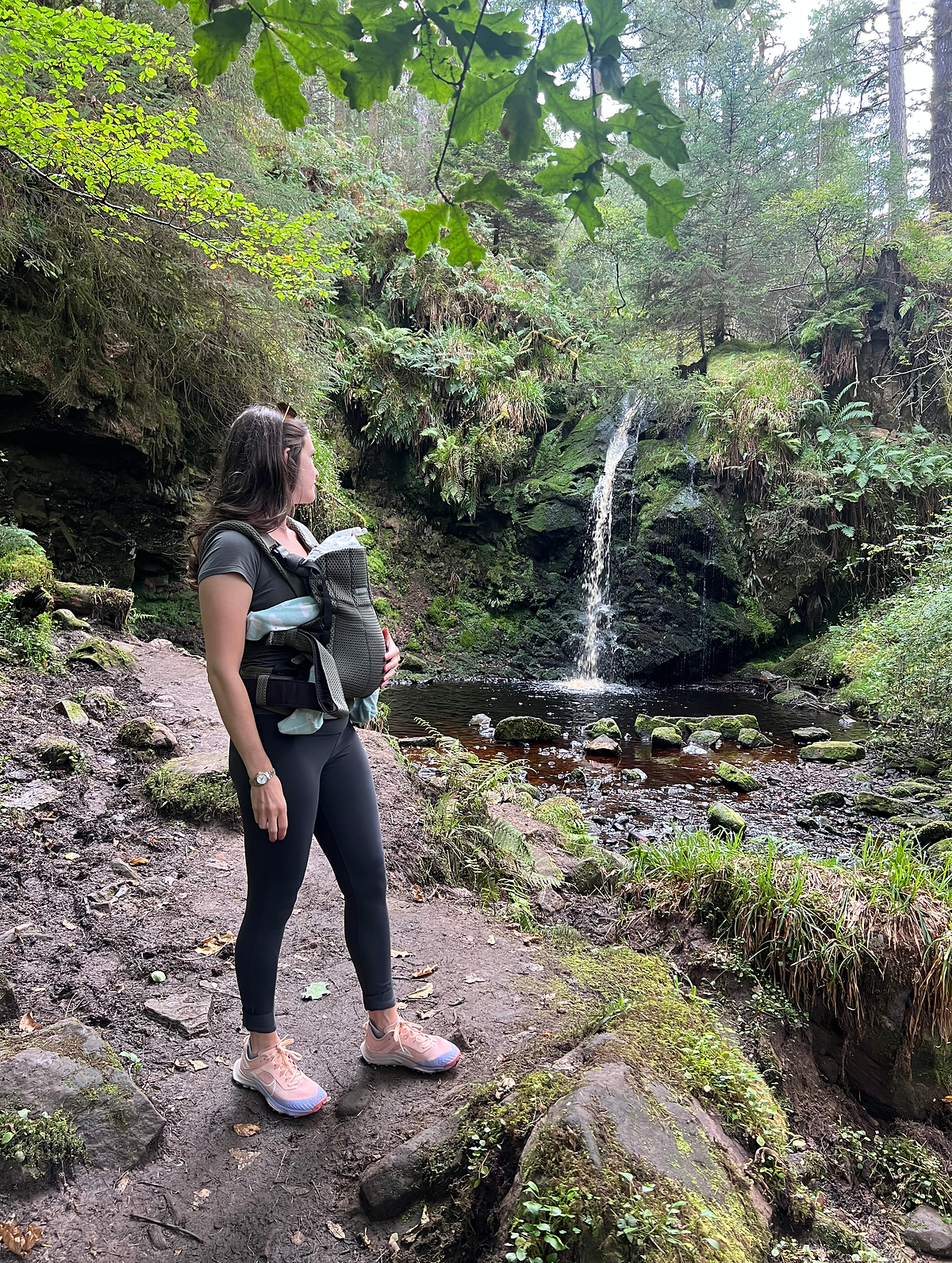A WEEKEND IN THE SCOTTISH BORDERS Woman with baby carrier at waterfall
