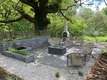Elevated view of the paved patio arrangement with chairs and a fireplace surrounded by gravel