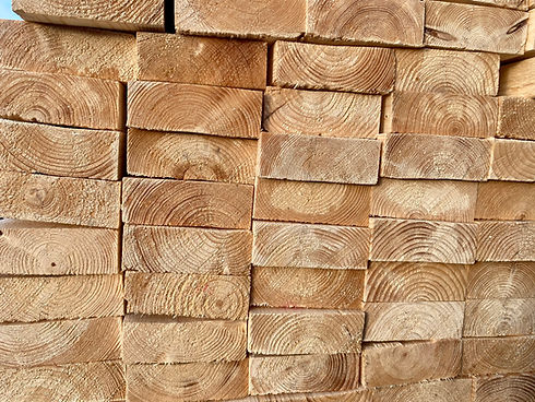 Stacked light brown timber planks showing natural wood grain patterns.