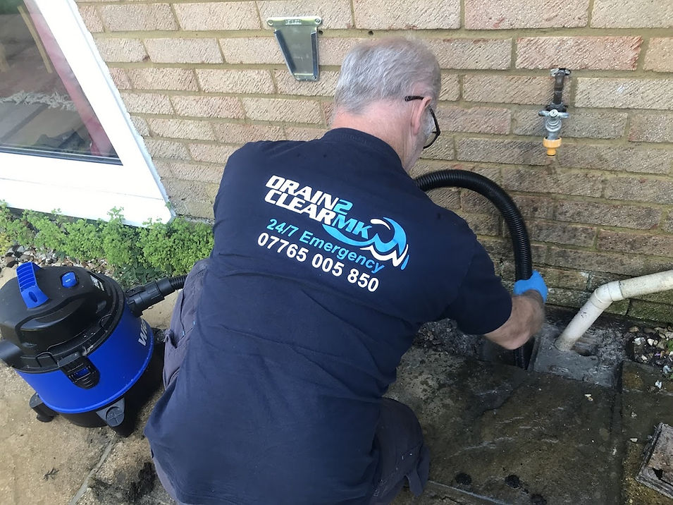 man cleaning drain with logo on top
