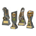 Trophy shop interior with a variety of gold and silver awards displayed on tables and shelves.