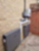 A complete solar panel system mounted on the exterior brick wall of a building
