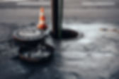 road drain with orange traffic cone