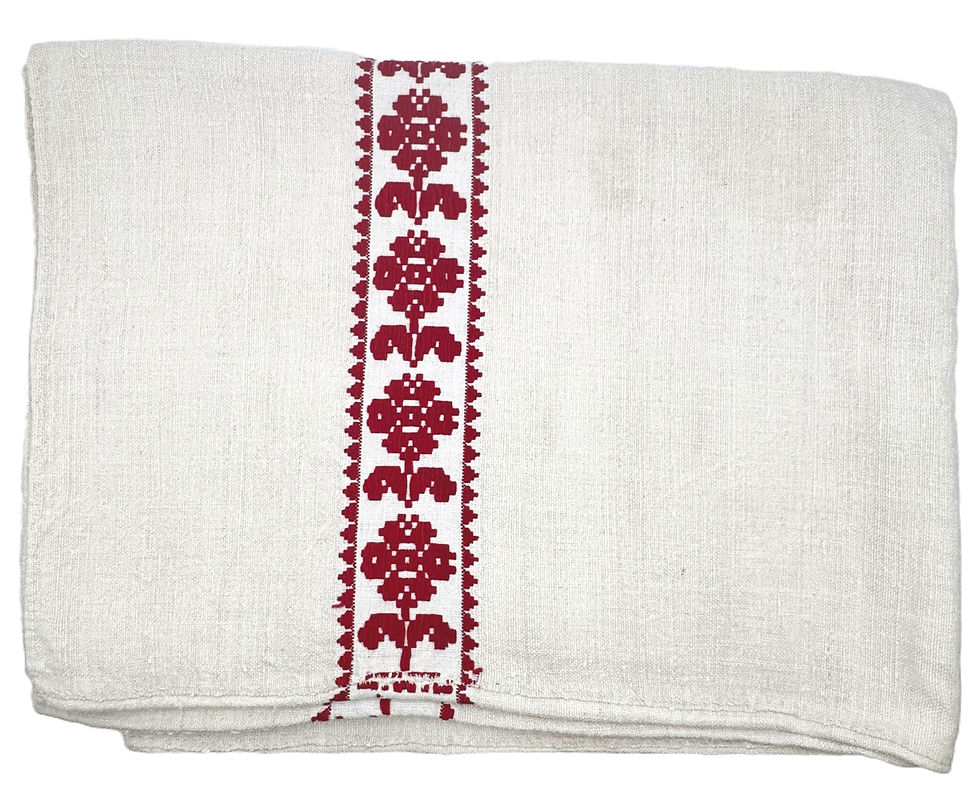 Folded off-white heirloom tablecloth featuring a deep red embroidered floral pattern running down the center.