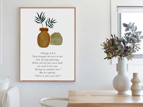 A Frame with a Bible verse and watercolor artwork hangs on the wall of a Christian interior designed home