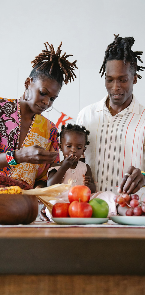 Black family preparing food together in a kitchen, representing cooperation and shared responsibility.