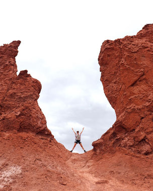 Person standing between red rock formations near San Pedro de Atacama Chile