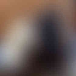 Bollyfit Active Weight Loss Challenge. Two women wearing head scarves. The coach is writing down the amount of weight the member has lost. The member stands on weight scales and wears black sportswear and trainers.