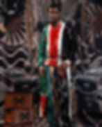 A man in colorful patterned attire holds shopping bags. Stacked boxes labeled "MXS" are beside him. Bold backdrop with graphic designs.