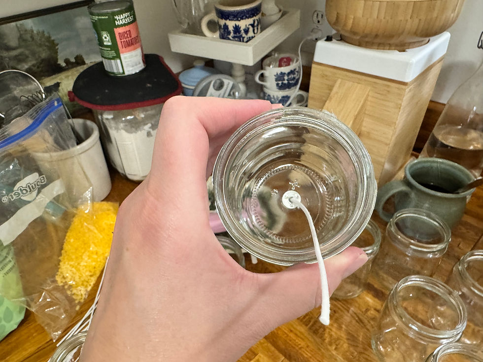 hand holding jar with candle wick