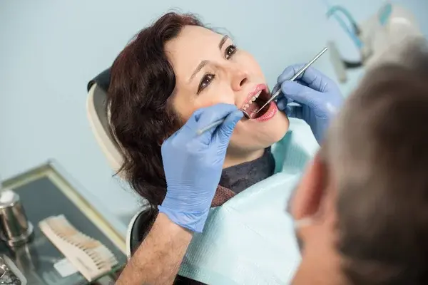 patiente dentaire qui se fait examiner la dentition,